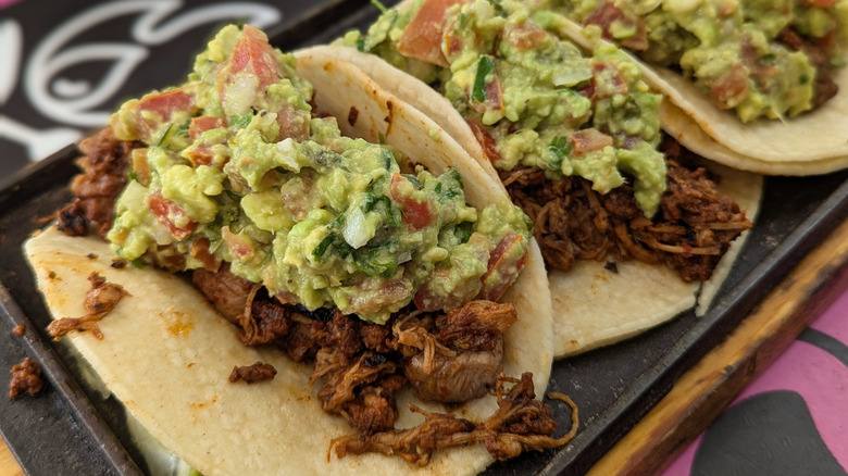 Pulled pork tacos with guacamole on them