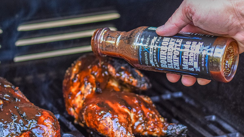 Elijah's Xtreme BBQ Sauce being poured on grilled meat