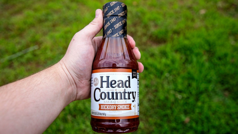 Handheld bottle of Head Country barbecue sauce