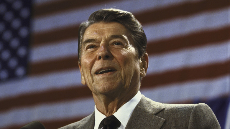 Ronal Reagan standing in front of an American flag