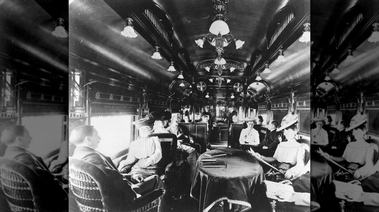 Black and white photo of early 1900s train dining car with passengers