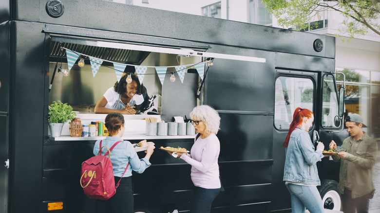 People enjoying food outside a food truck