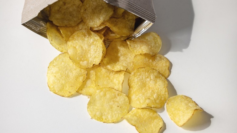 Potato chips spilling out of a foil bag