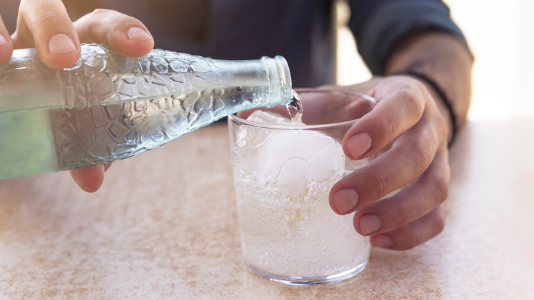 pouring sparkling water into glass