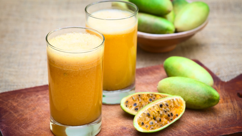 Banana passionfruit juice next to the halved fruit