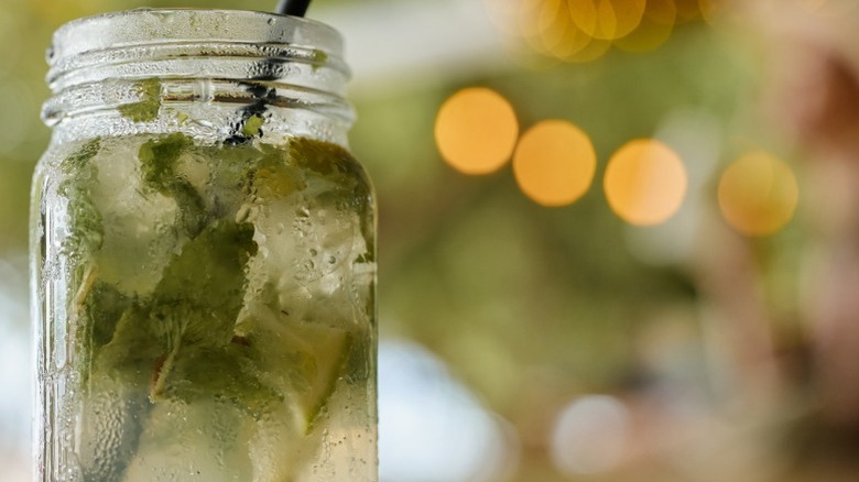 Close-up of cocktail in mason jar with straw.