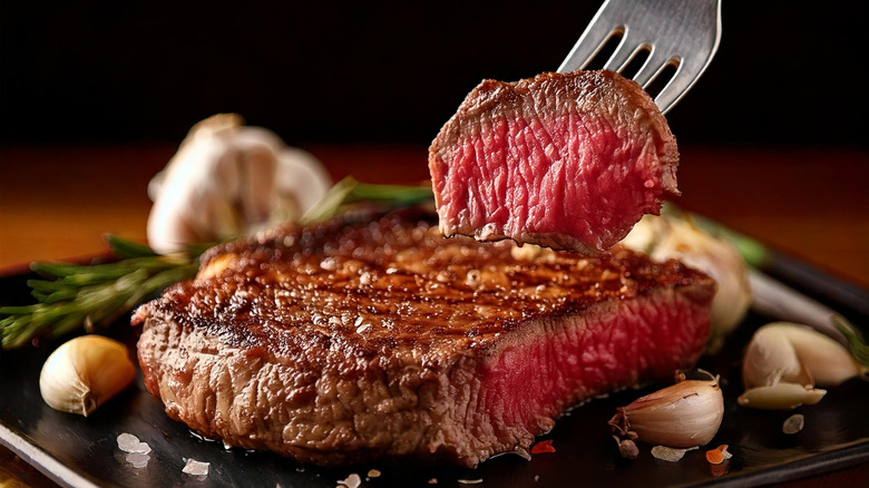 A person cutting into a steak