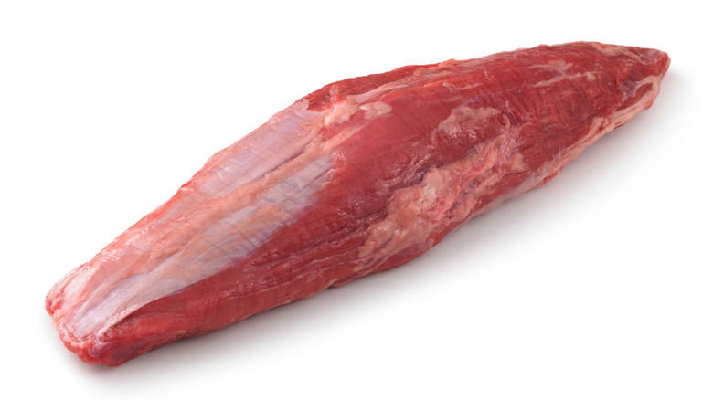 A raw cut of beef known as the shoulder petite tender against a white background