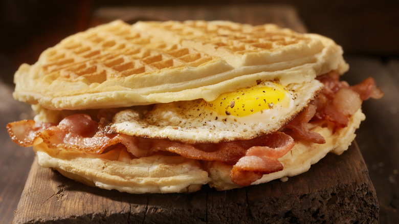 layered waffle breakfast sandwich with seasoned fried egg and crispy bacon