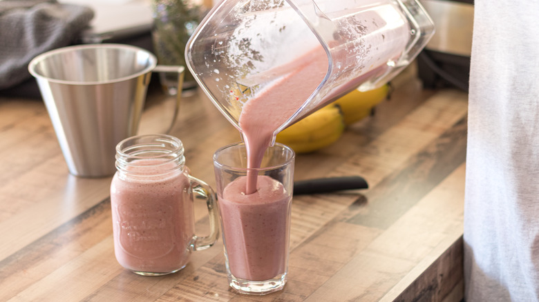 Pouring a homemade fruit smoothie in a glass