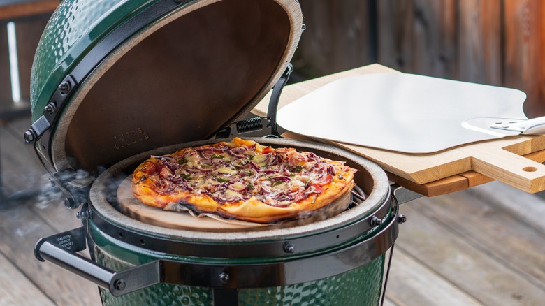 Pizza being cooked on an outdoor grill