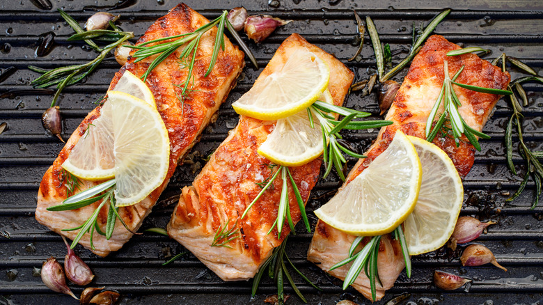 salmon on the grill with herbs and lemon slices