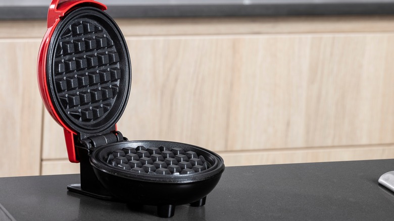 An open waffle iron on a counter