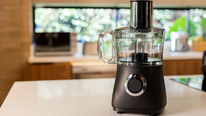 A homecook blending greens in a food processor