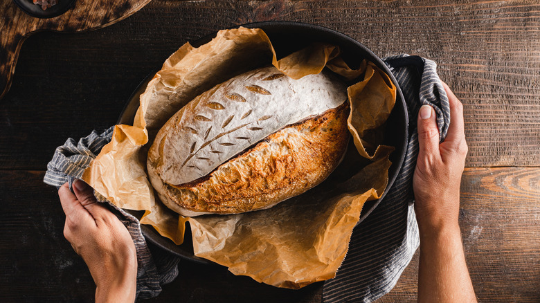 Freshly baked loaf of sourdough bread in a baking tray.