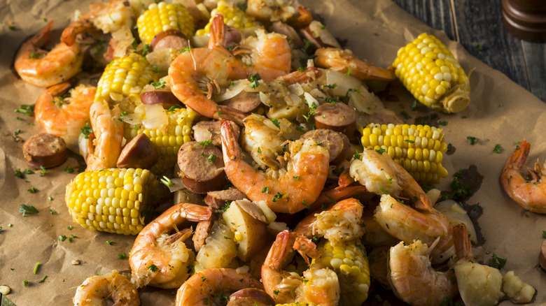 A shrimp boil made with corn and sliced sausage