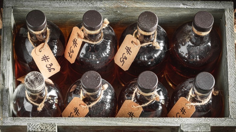 Eight bourbon barrels sitting upright in a storage container