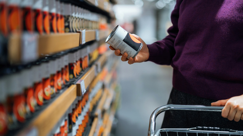 person holding canned food