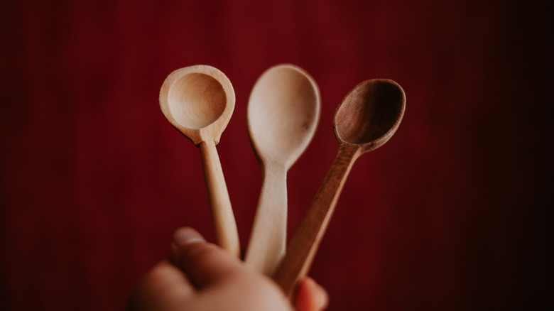 Three wooden spoons on a red background