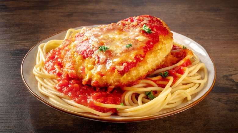 Chicken parmesan on a plate of spaghetti