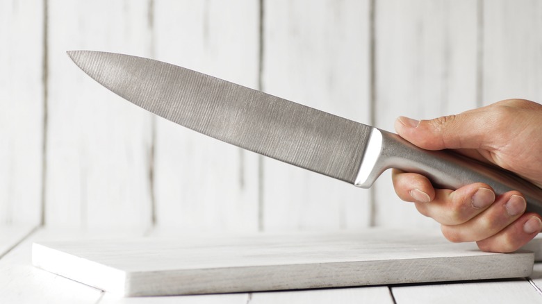 One hand holding a sharp kitchen knife