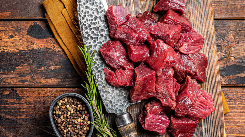 Raw, diced beef sitting on a cutting board.