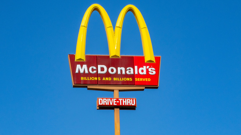 A large McDonald's drive-thru sign in the sky during the day