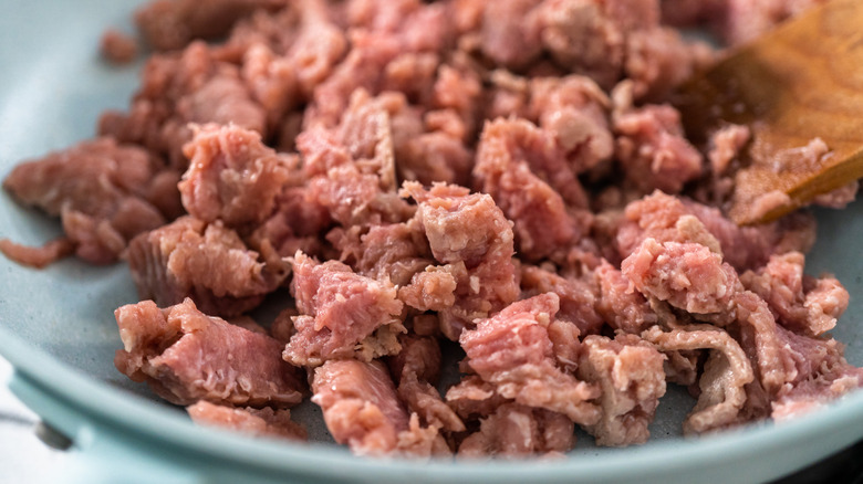 Ground turkey being cooked in a skillet.