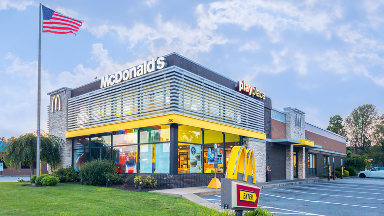 The exterior of a McDonald's playplace location with the US flag outside of it