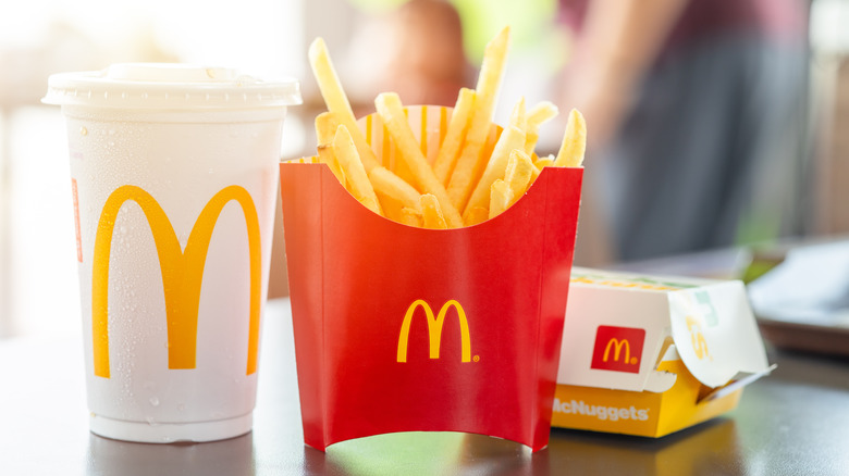 A McDonald's drink, fries, and McNuggets sit on a table