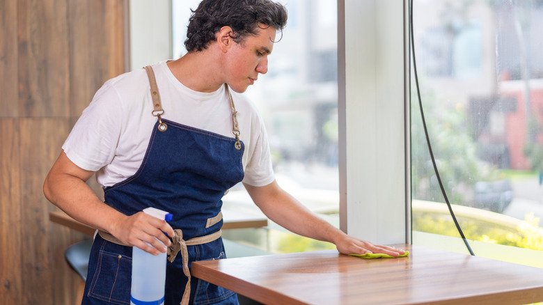 Waiter cleaning restaurant table