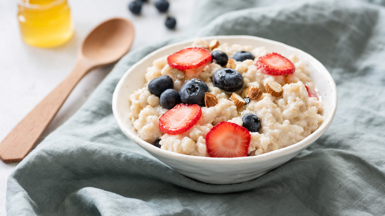 A bowl of oatmeal with berries on top of it.