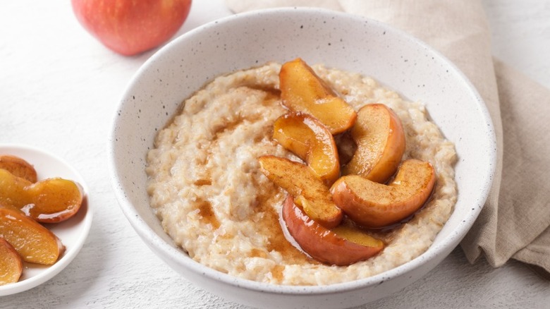 Cooked apples sitting on top of a bowl of oatmeal.