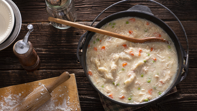 A cast-iron Dutch oven filled with chicken and dumplings