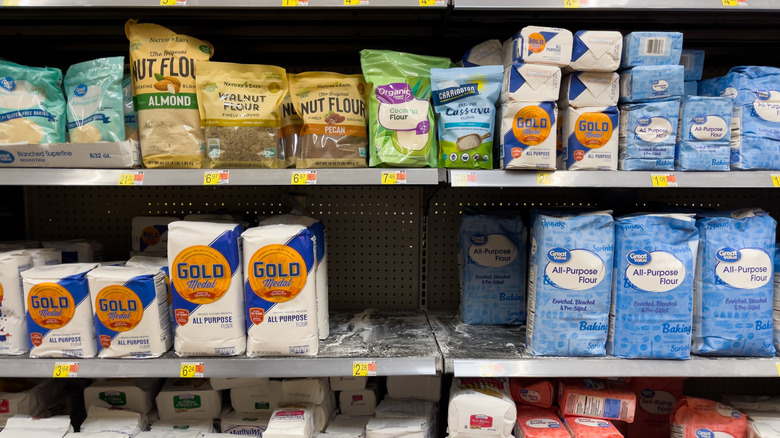 Different brands of flour displayed on a store shelf