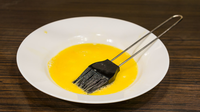 Egg wash in a bowl with a brush