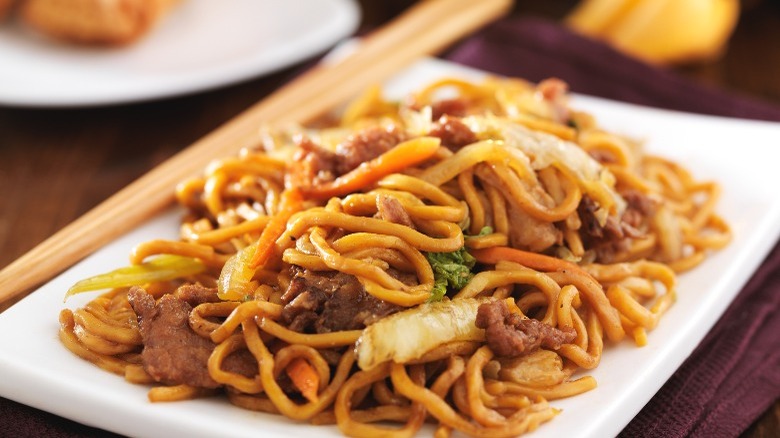 beef lo mein on plate with chopsticks