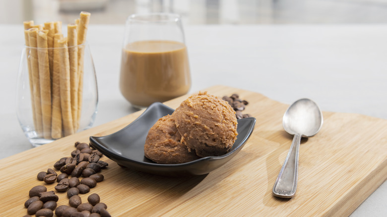 Two scoops of coffee ice cream next to coffee and coffee beans