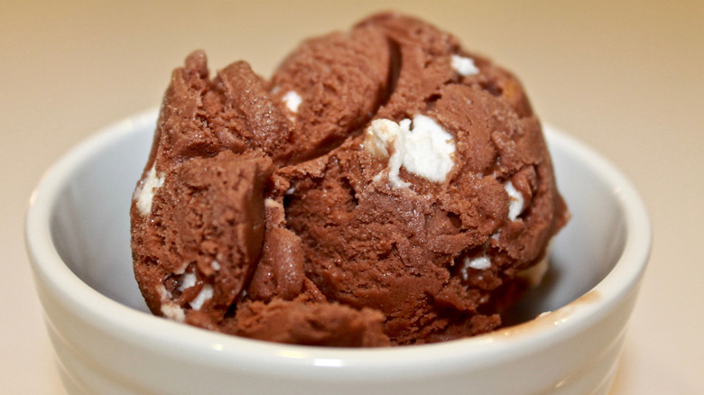 Scoop of rocky road ice cream in a white bowl