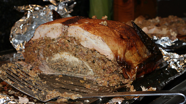 A cooked turducken, slied in half to show the layers of chicken, duck, turkey, and stuffing