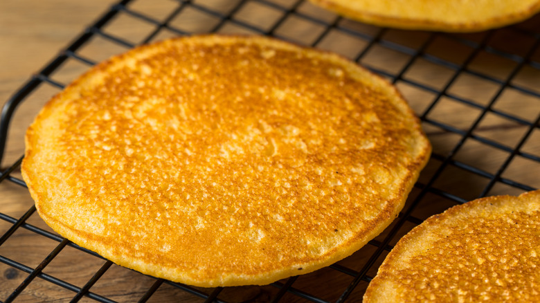 homemade johnnycakes cooling on an iron rack