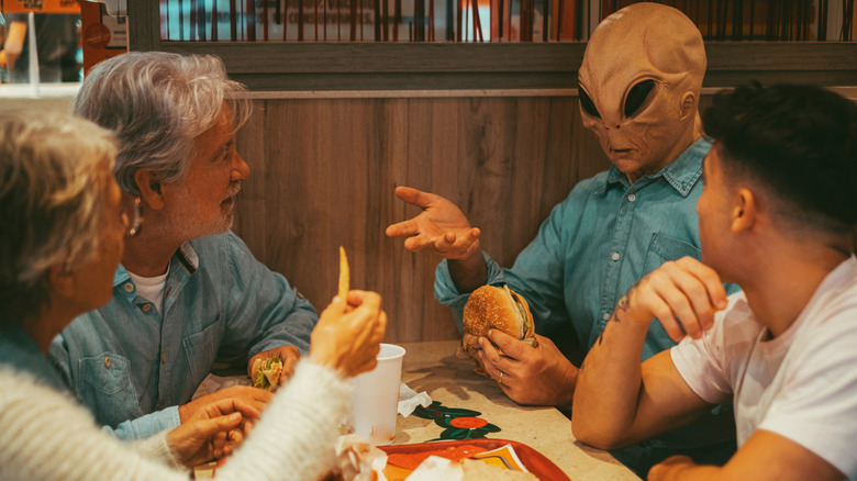 family eating dinner with an alien