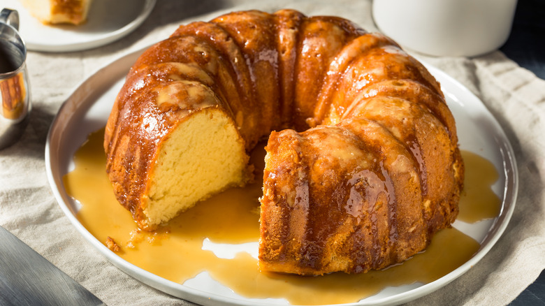 rum-glazed bundt cake on a white plate on top of a beige cloth napkin