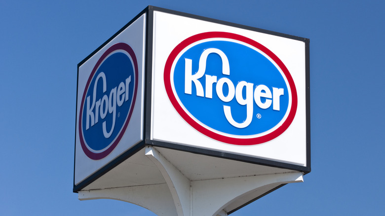 A cubed Kroger sign in the sky during the day