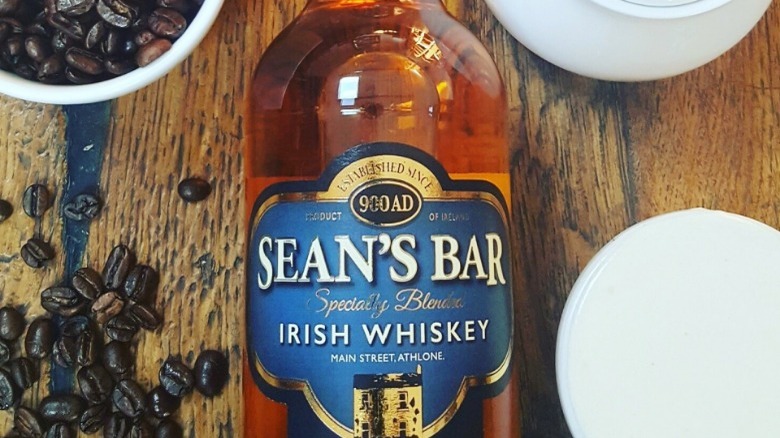 Bottle of Sean's Bar whiskey on a table with coffee beans