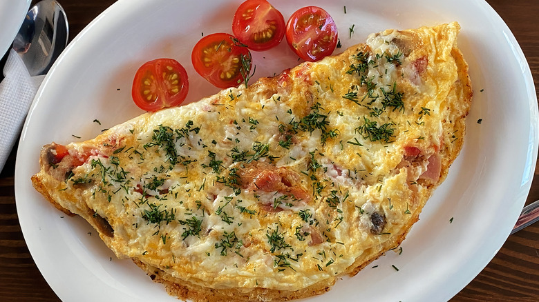 An omelet with herbs and cherry tomatoes