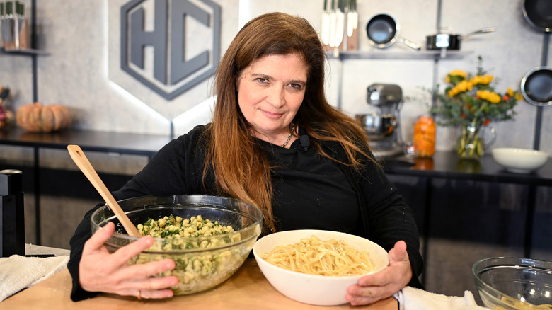 Alex Guarnaschelli holding two big bowls of food