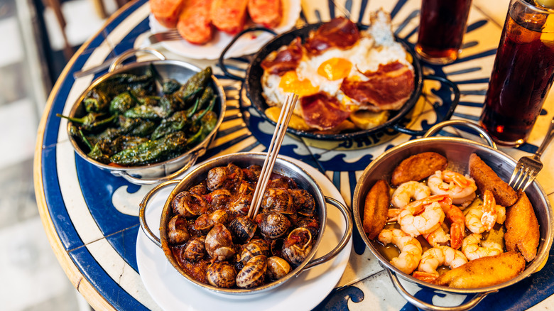 Classic French cuisine on a table, including escargot and seafood dishes