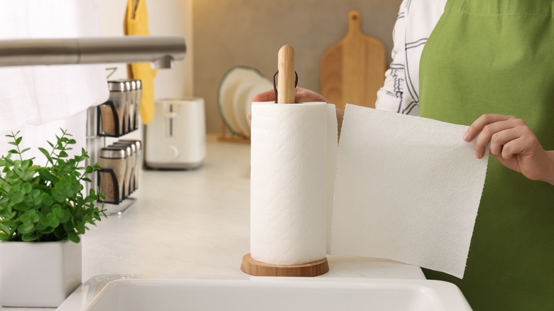 woman tearing off piece of paper towel