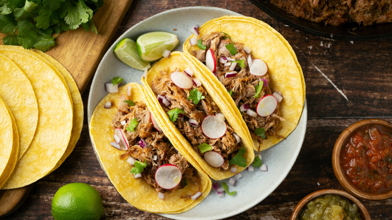 3 soft tacos with lime, cilantro, and radish on top